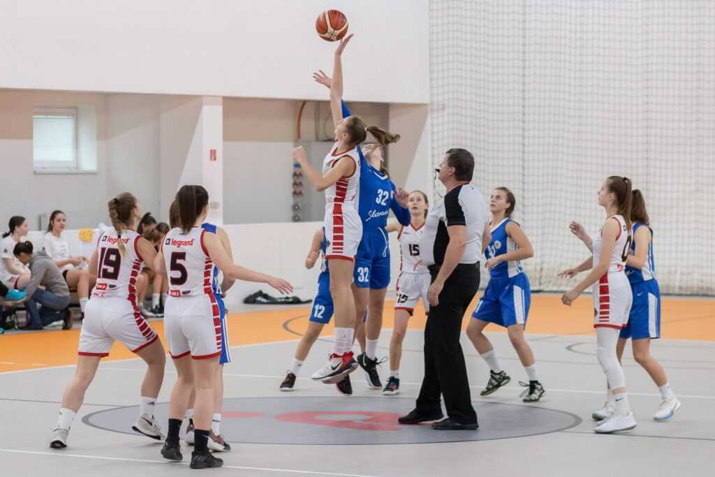 Dynamic basketball scene with players in action on an indoor court.